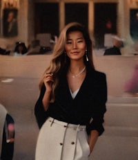 a woman in a white skirt and black jacket